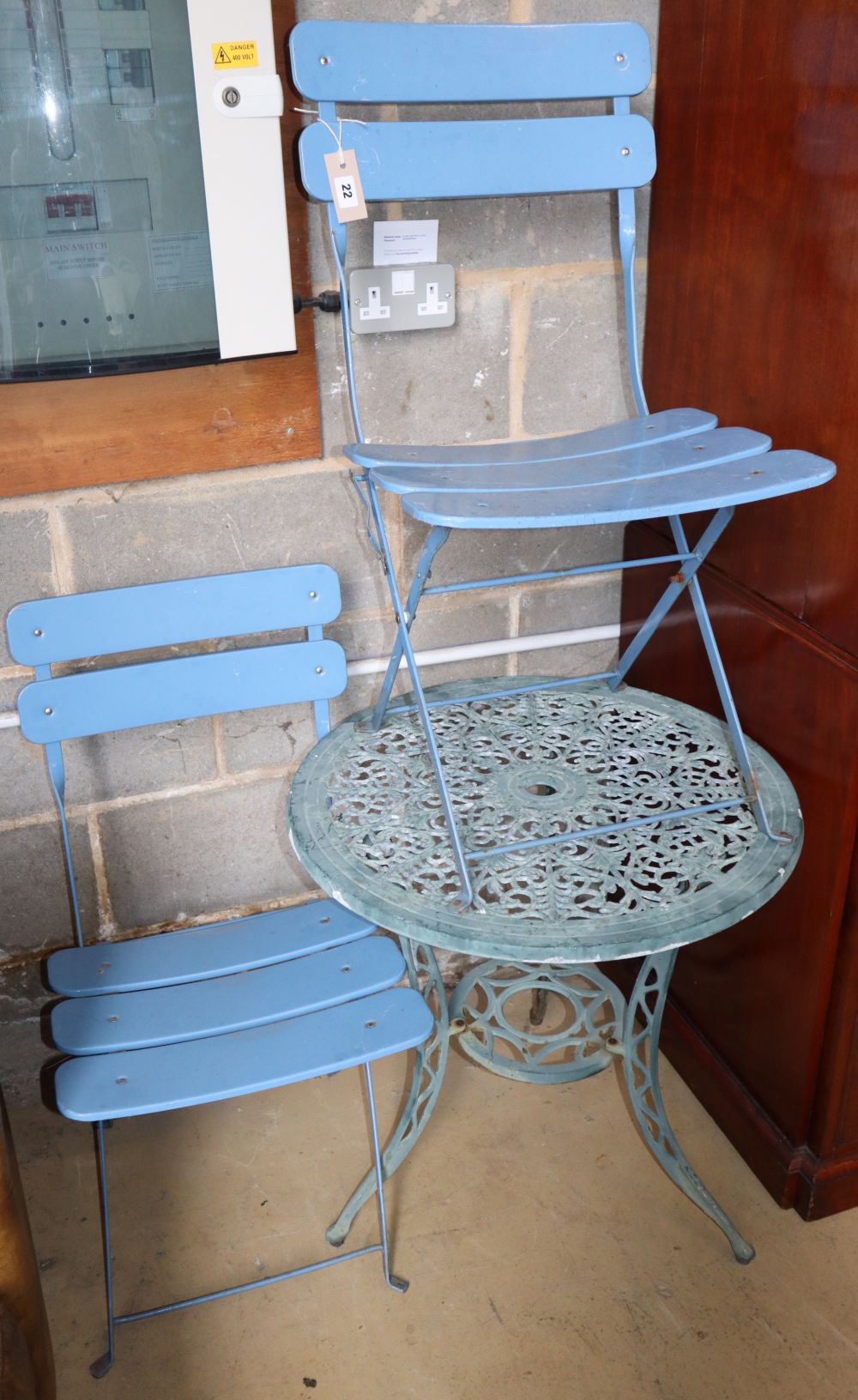 A painted aluminium circular garden table, 60cm diameter together with a pair of folding chairs
